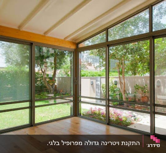 סגירת מרפסת באלומיניום עם ויטרינות זכוכית גדולות המשקיפות לגינה